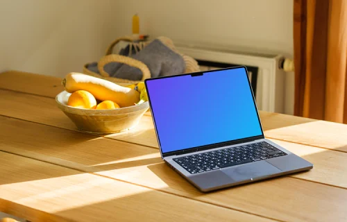 MacBook Pro mockup on a table with photo frames in the background