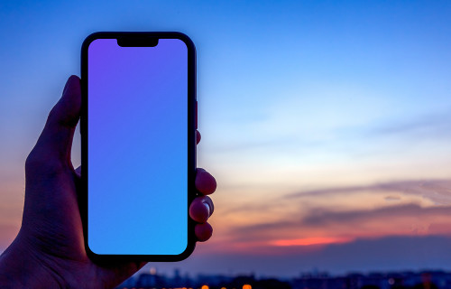 Male hand holding an iPhone 13 mockup