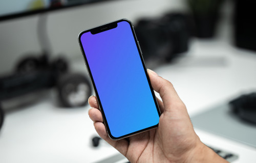 Man holding up an iPhone 12 mockup