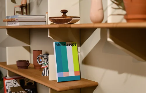 Mockup of a C-format book on a wooden shelf with decor