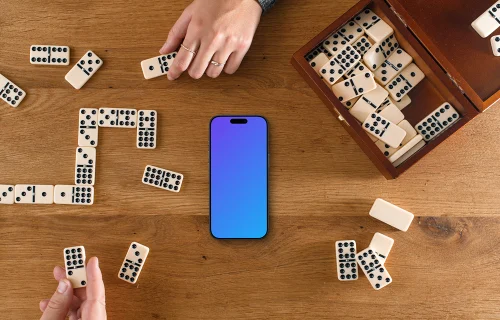 People playing dominoes next to the iPhone mockup