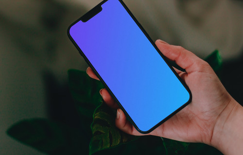 Person holding up an iPhone 13 Pro mockup