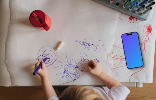 Smartphone mockup beside child's artwork