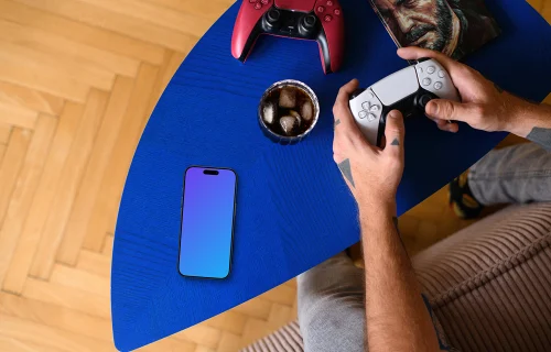 Smartphone mockup beside gaming gear on coffee table