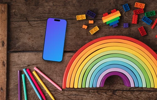 Smartphone mockup on a wooden table with rainbow items