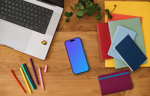 Smartphone mockup with rainbow pens and notebooks