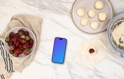 Strawberries and sweets next to the iPhone mockup