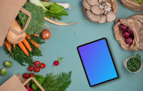 Tablet mockup between bags full of vegetables