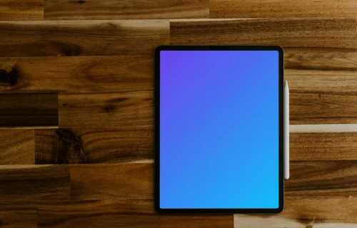 Tablet mockup on a wooden table with Apple pencil