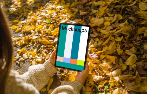 Woman holding an iPad Air in the leaves mockup
