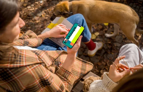 Woman holding an iPhone 14 near dog mockup