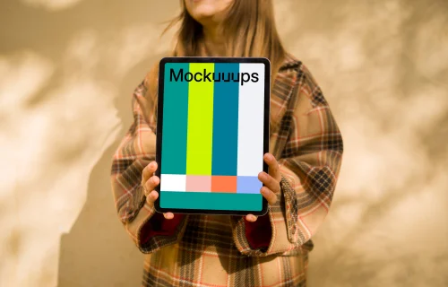 Woman standing in front of wall holding an iPad Air mockup