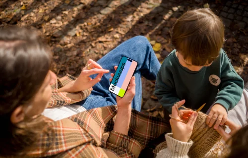 Woman typing on an iPhone 14 Pro next to the kid mockup