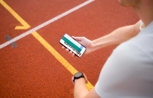 Young runner holding an iPhone 14 Pro mockup