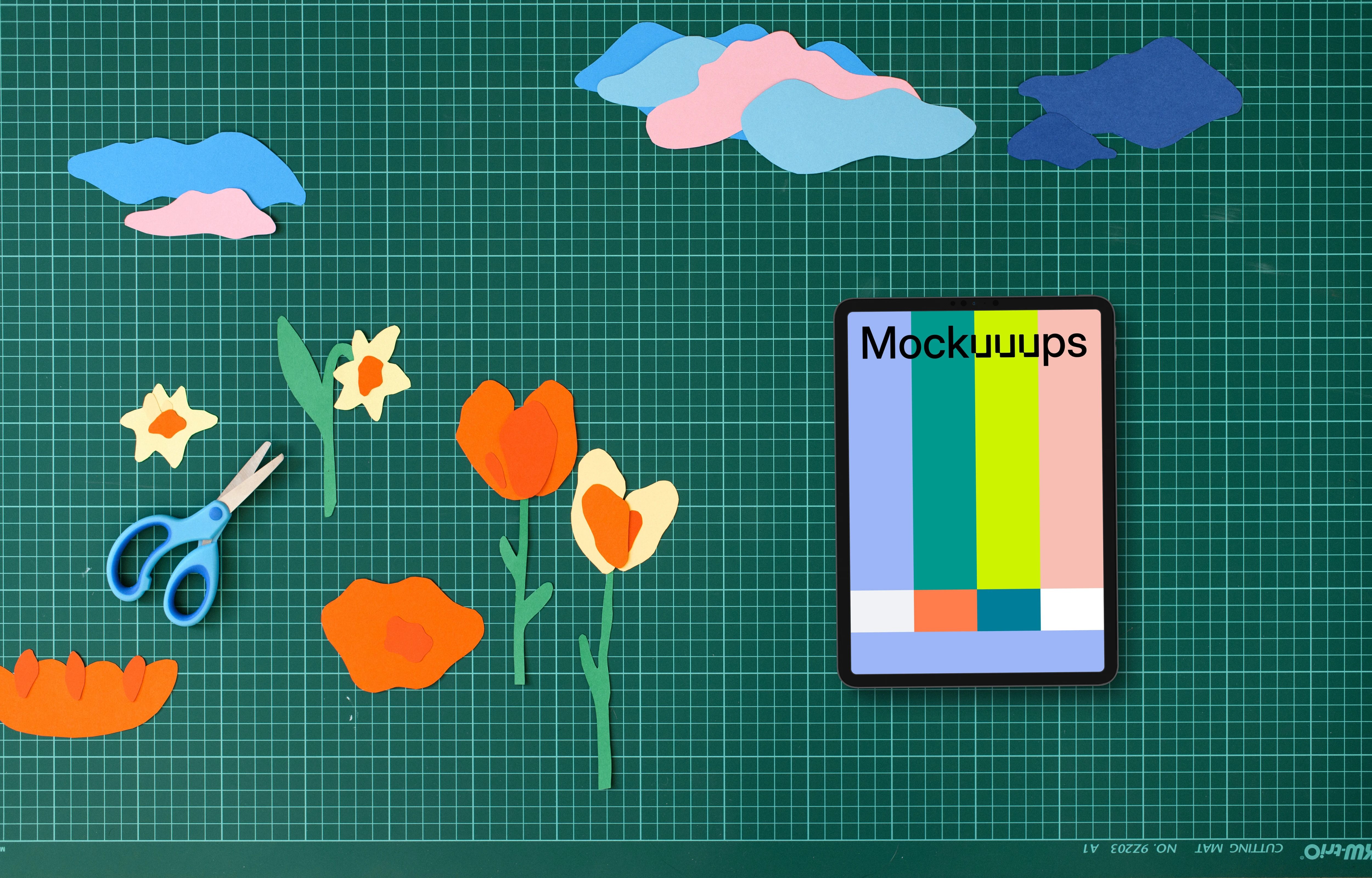 Tablet mockup on a crafting table with paper decorations
