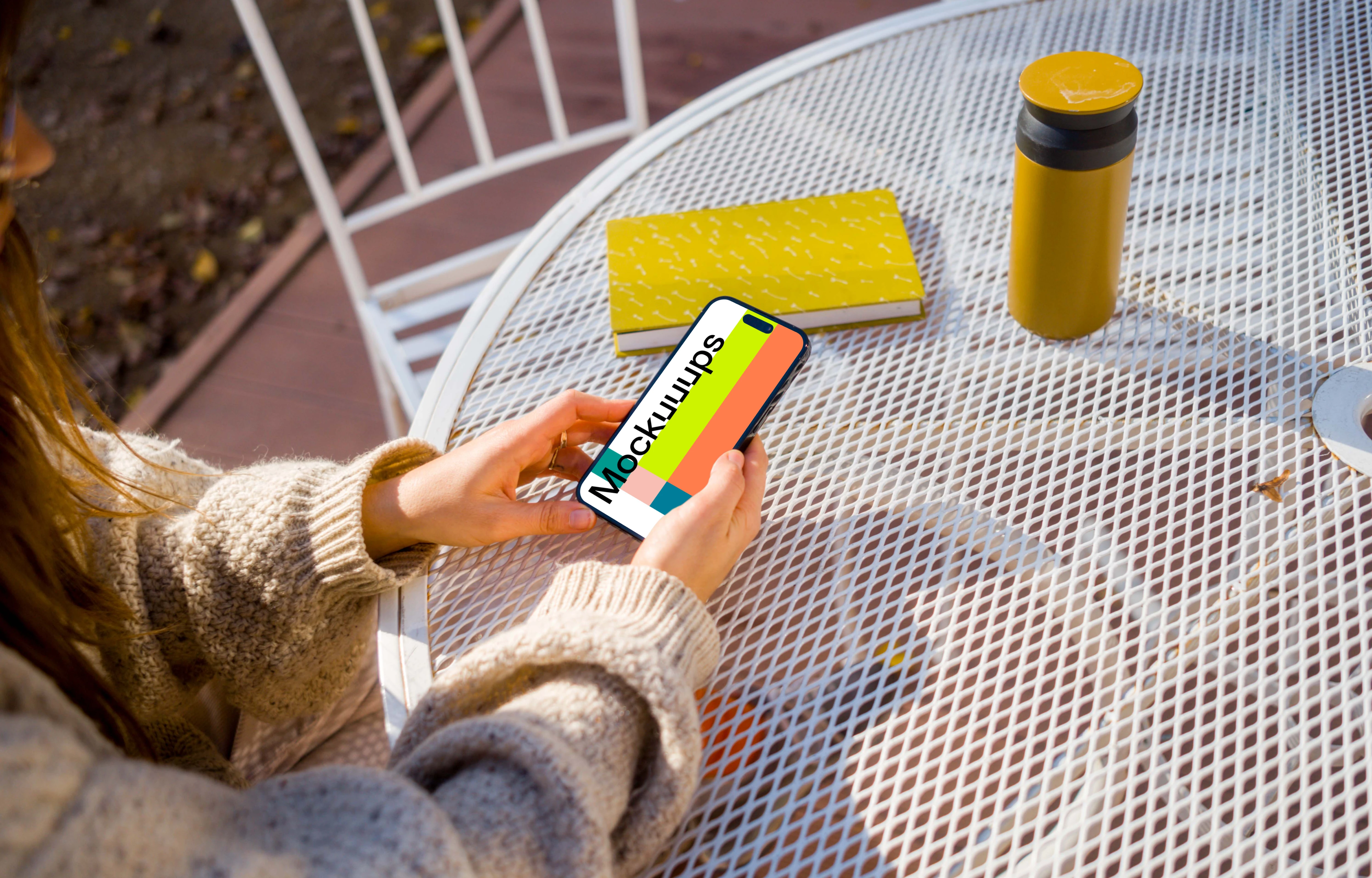 Woman in sweater holding an iPhone mockup