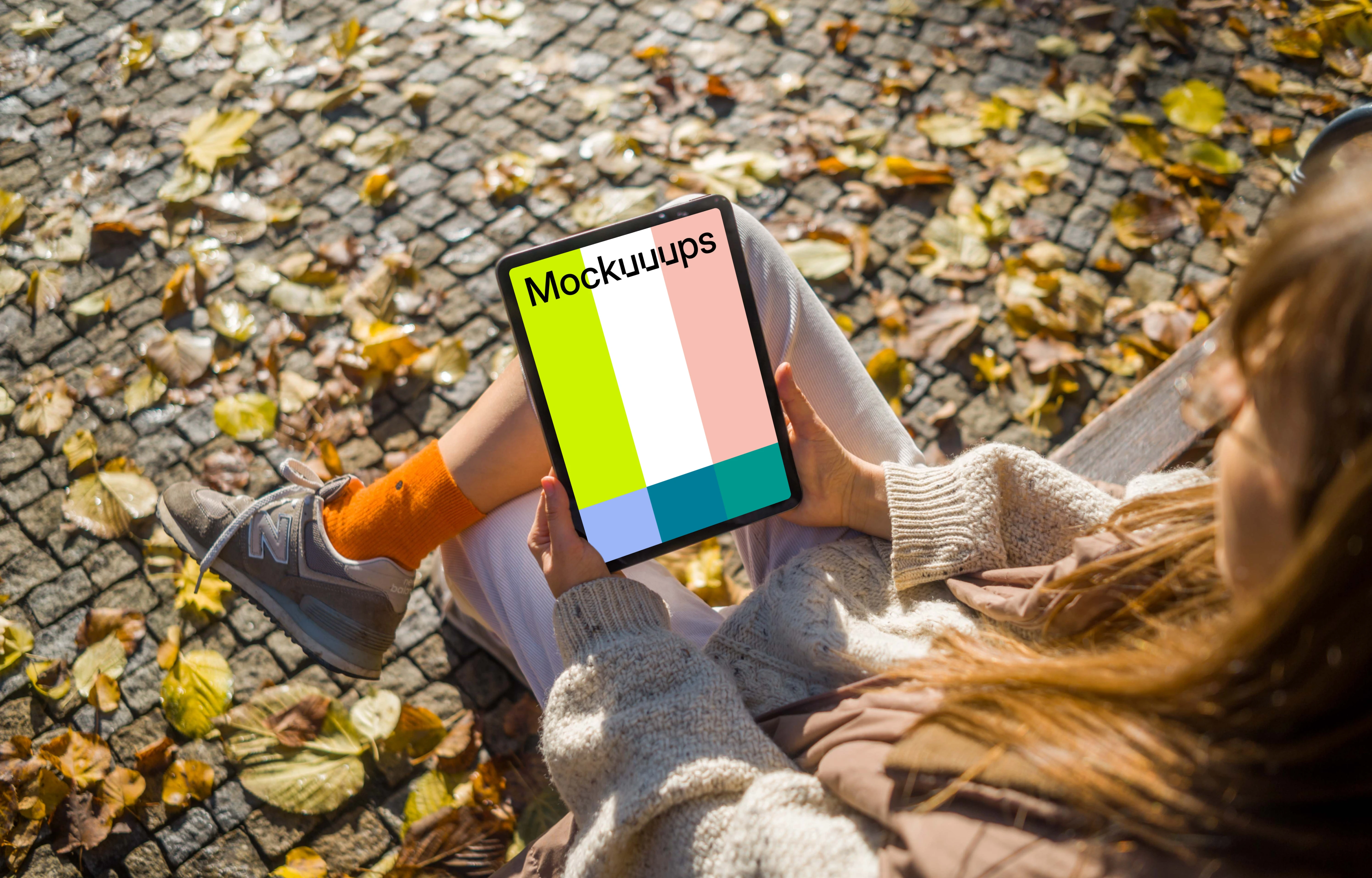 Woman sitting on a bench holding an iPad Air mockup