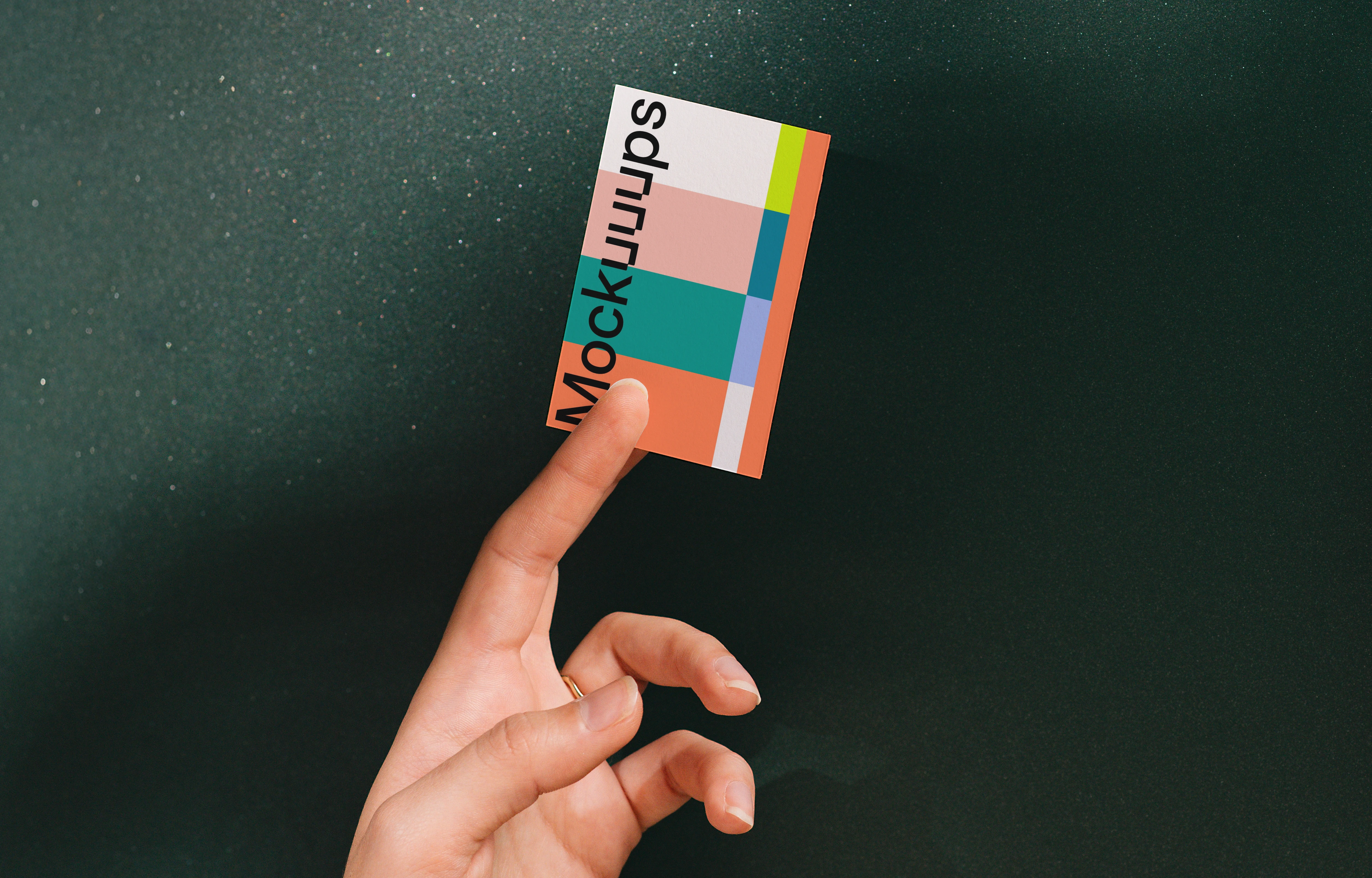 Business card mockup held by a hand on a dark background