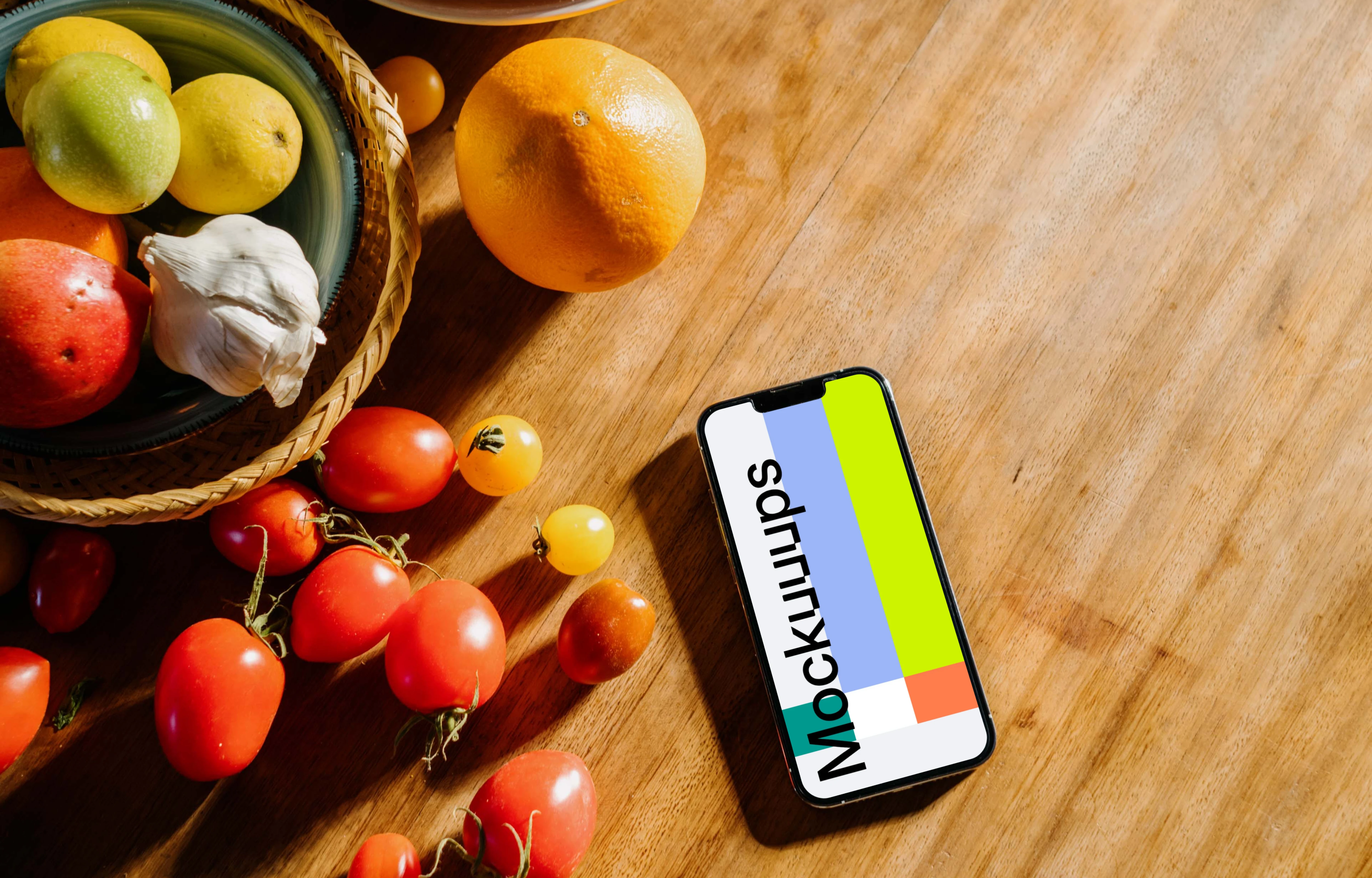 iPhone 13 Pro mockup on a table next to a bowl of fruits