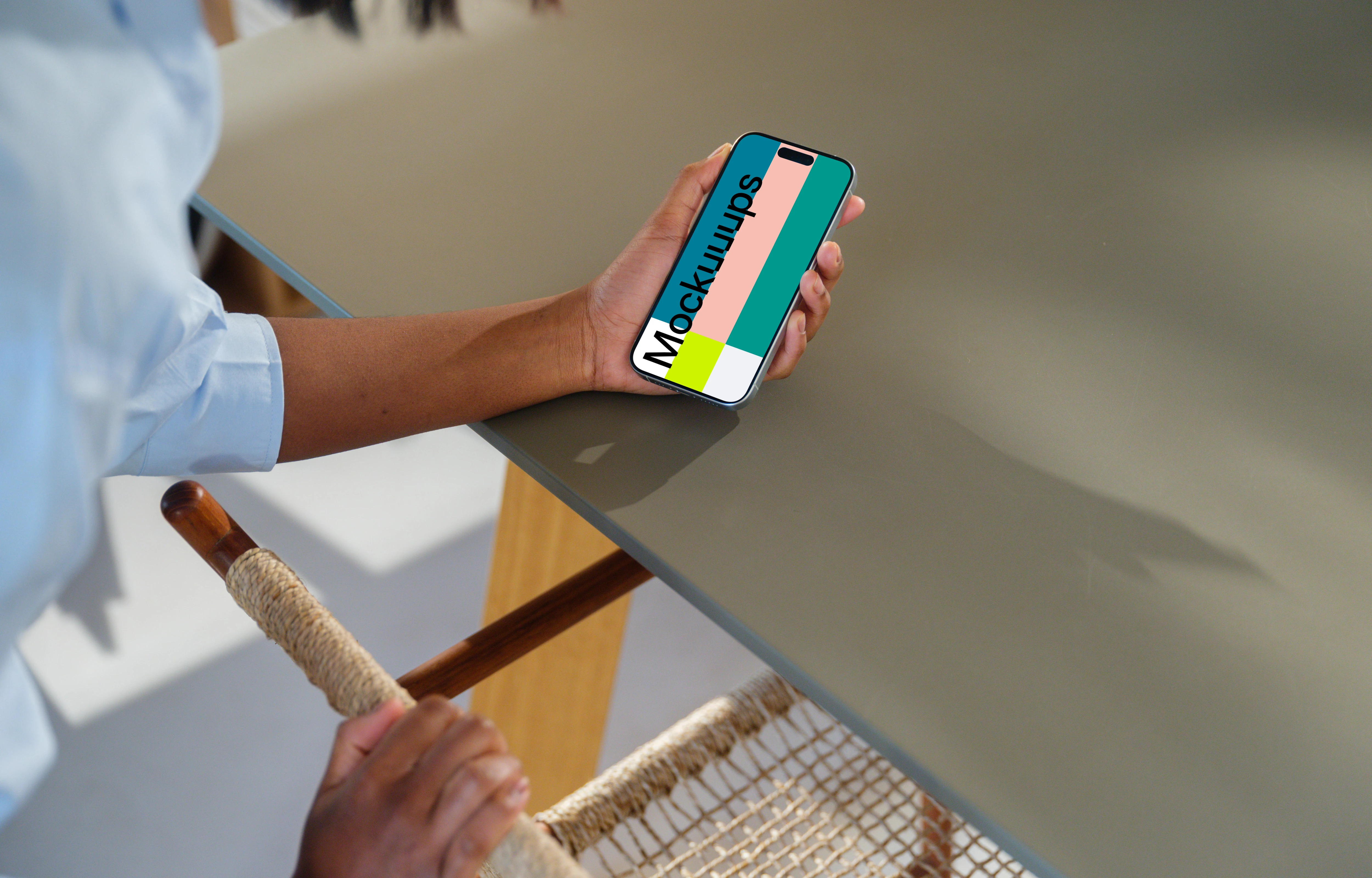 iPhone 15 Pro mockup in a woman's hand at a modern desk