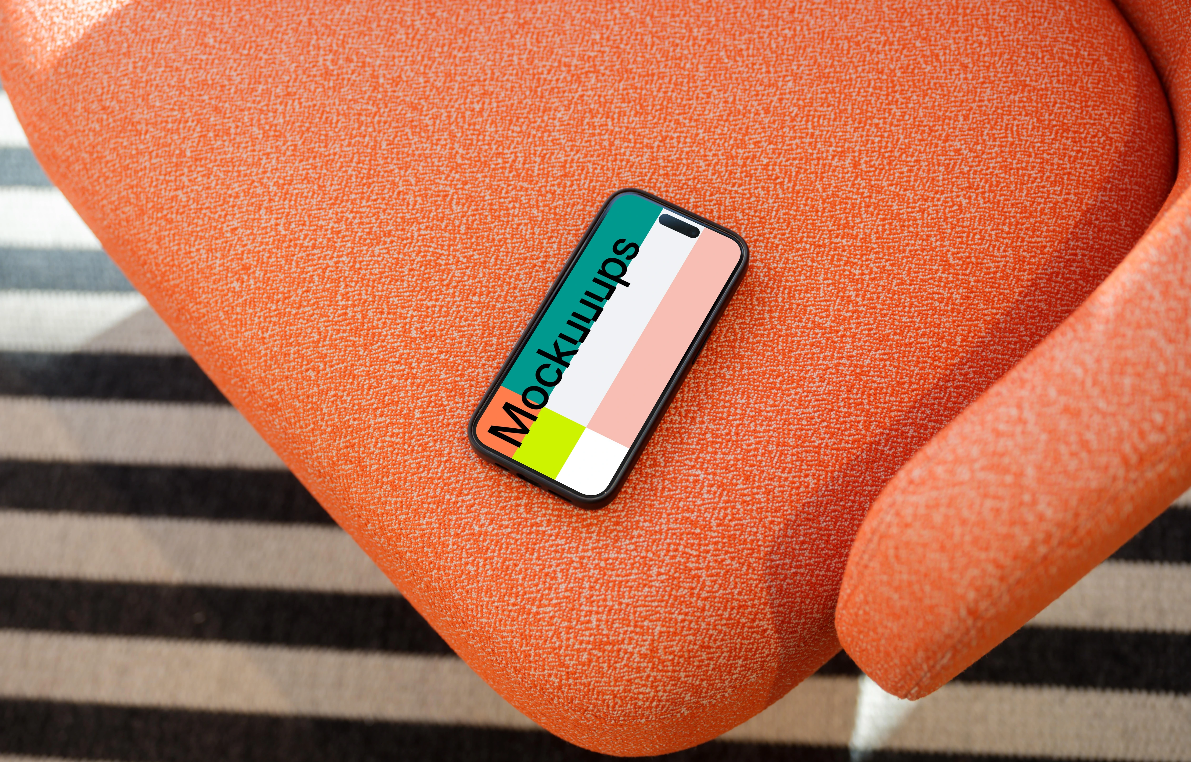 iPhone 15 Pro mockup on a vibrant orange armchair