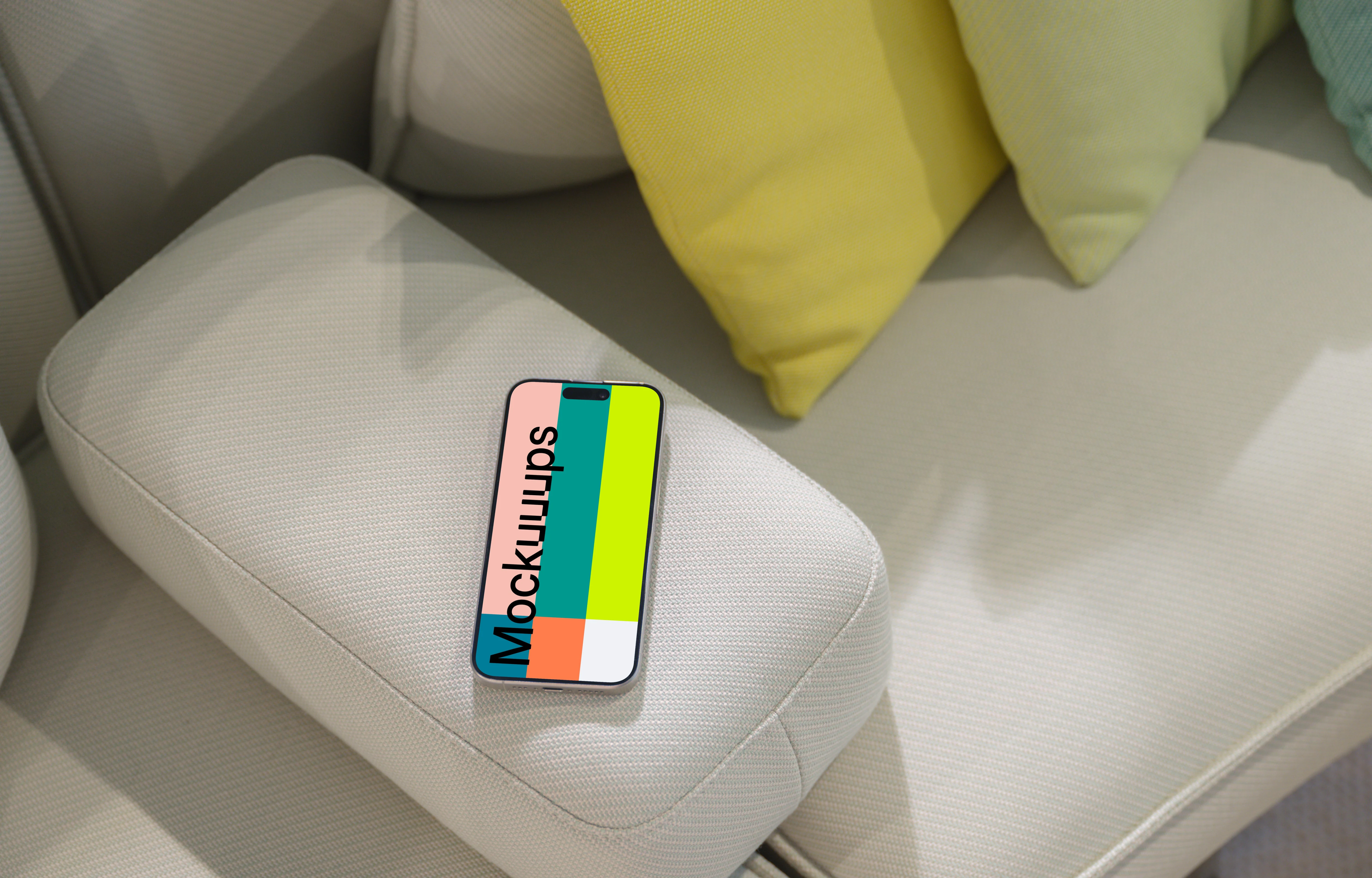 iPhone 15 Pro mockup on modern couch with colorful cushions