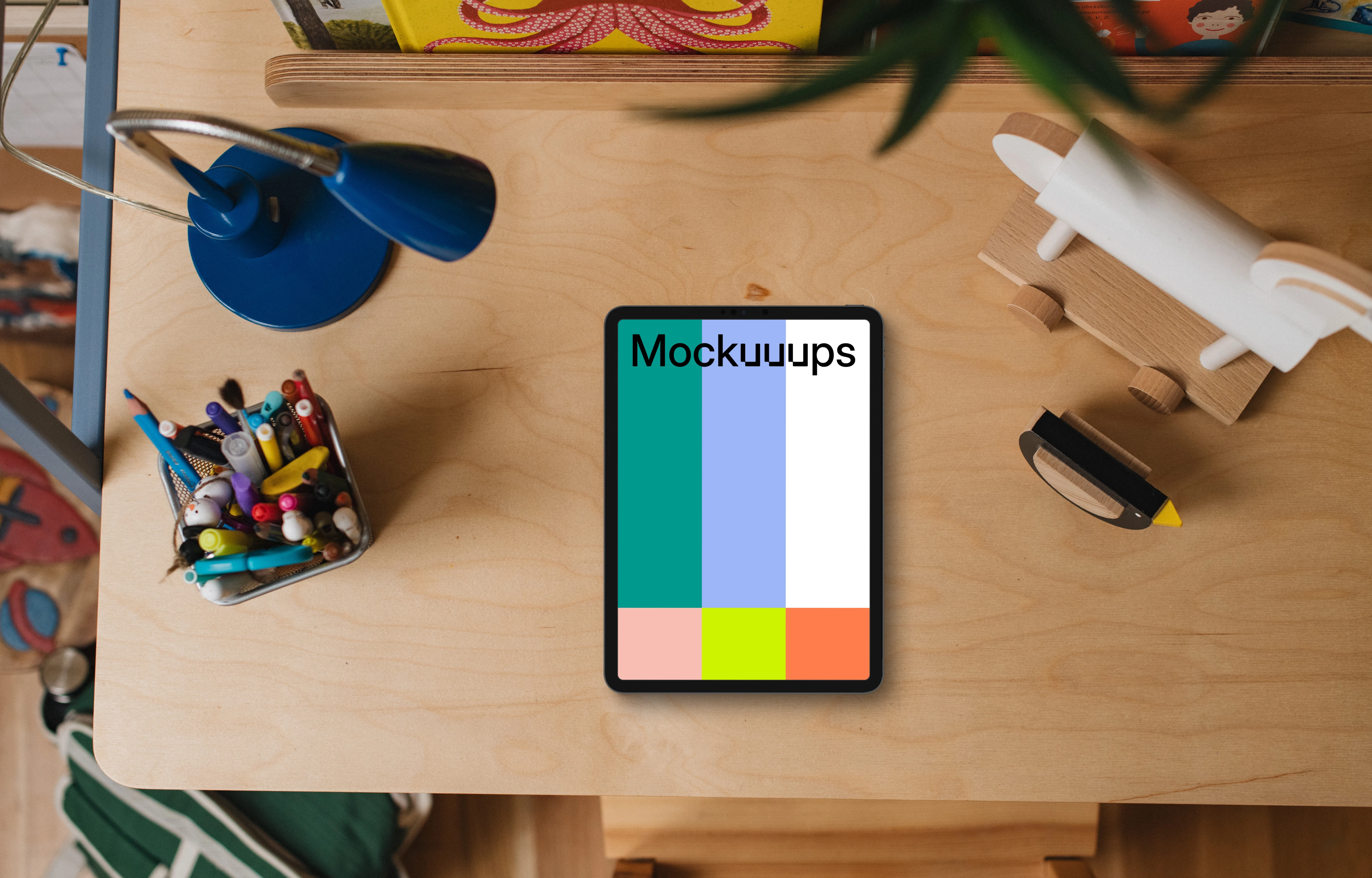 Tablet mockup on a child's desk with toys