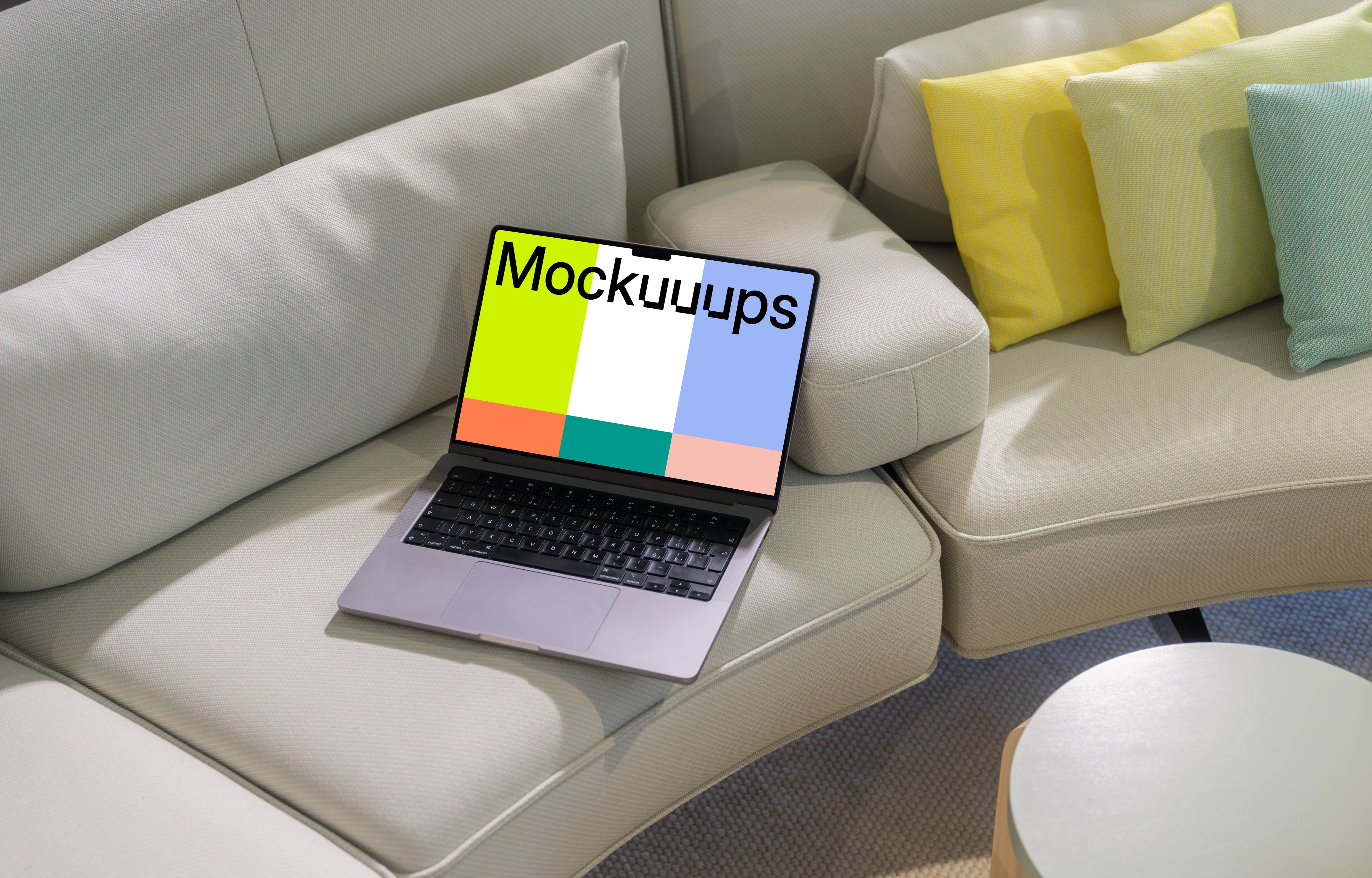 MacBook Pro mockup on a modern beige sofa with colorful pillows