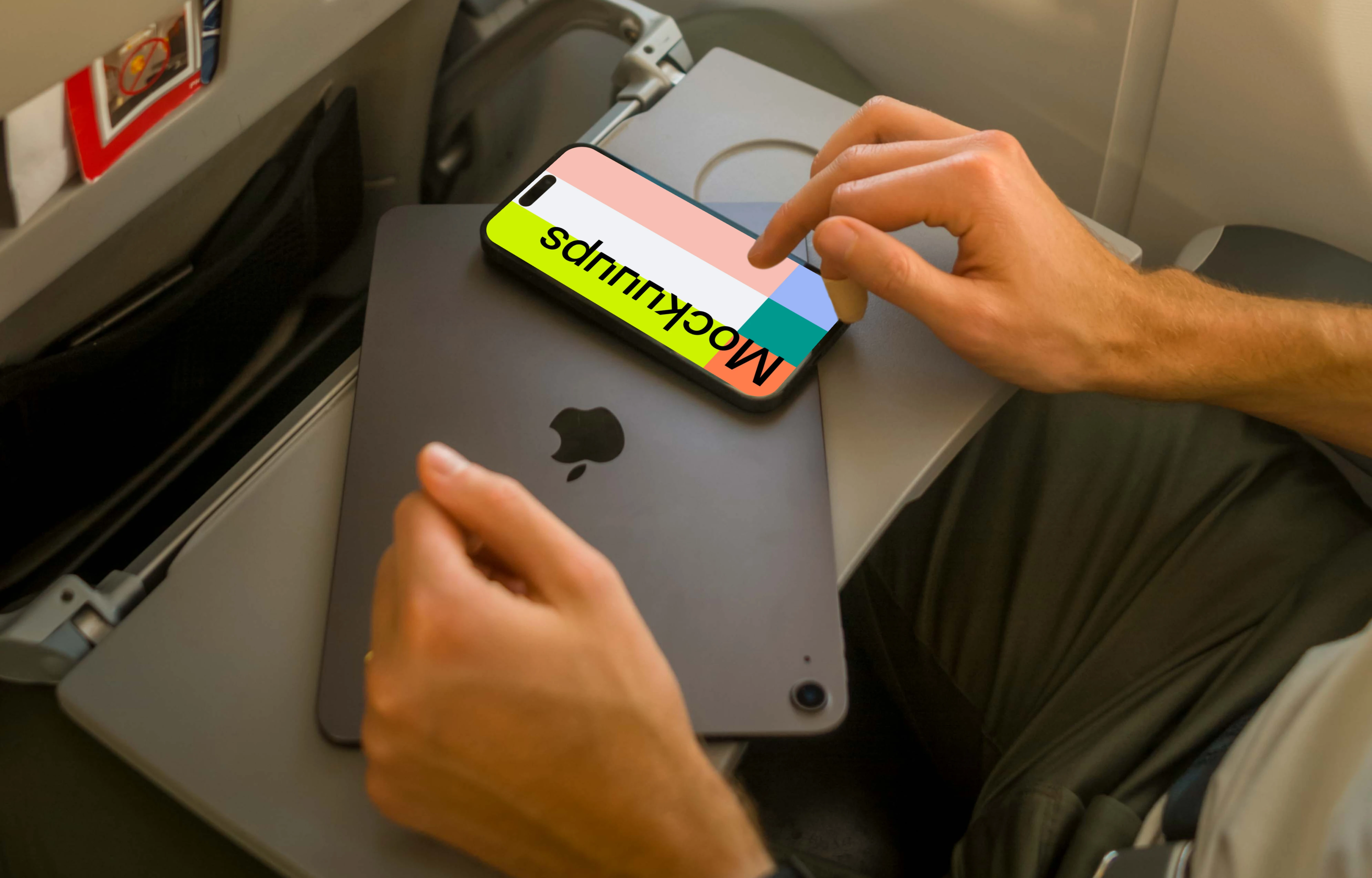 Man using iPhone 14 Pro mockup while sitting in airplane