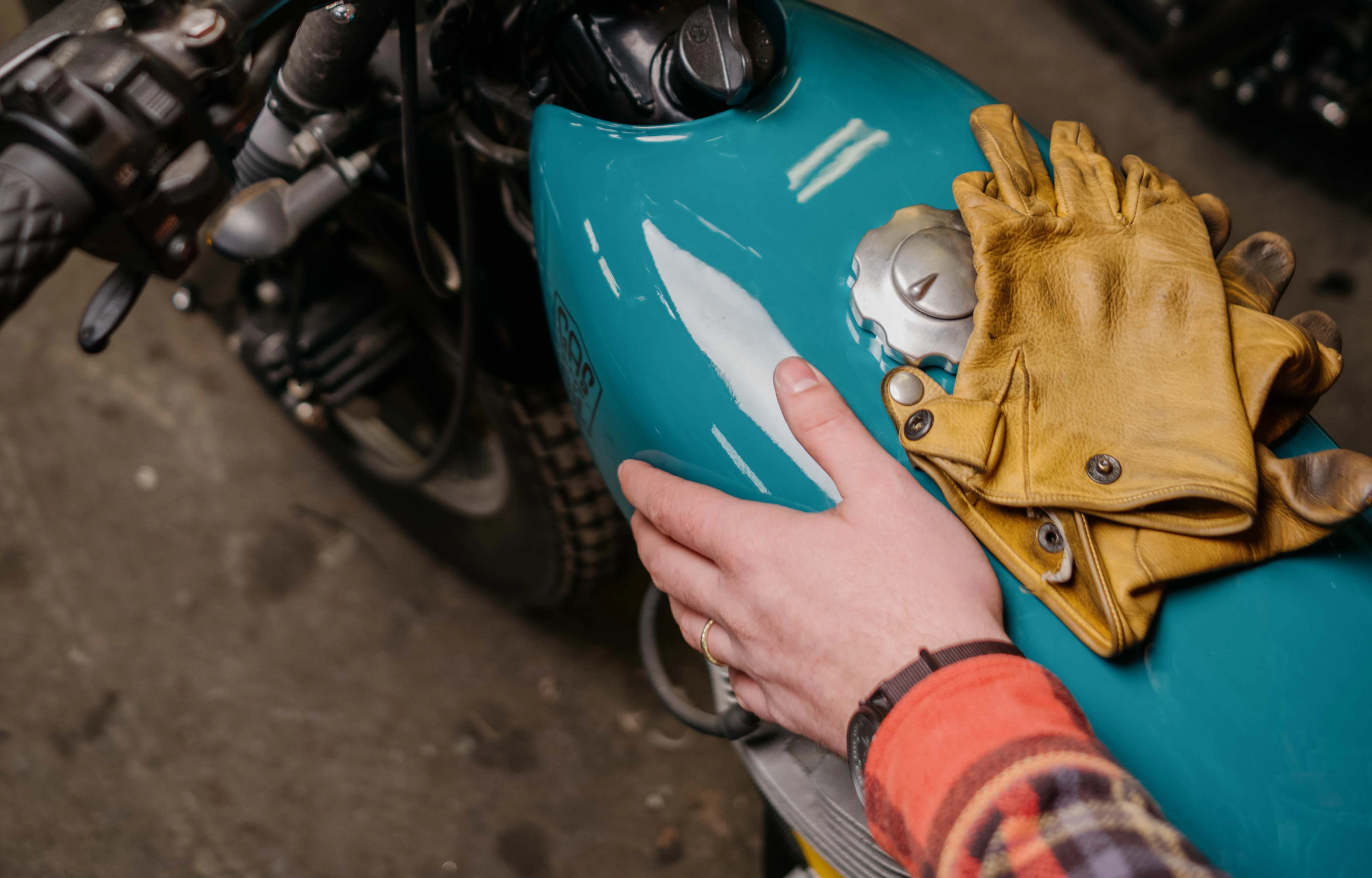 Man with a motorcycle holding an iPhone 13 Mockup