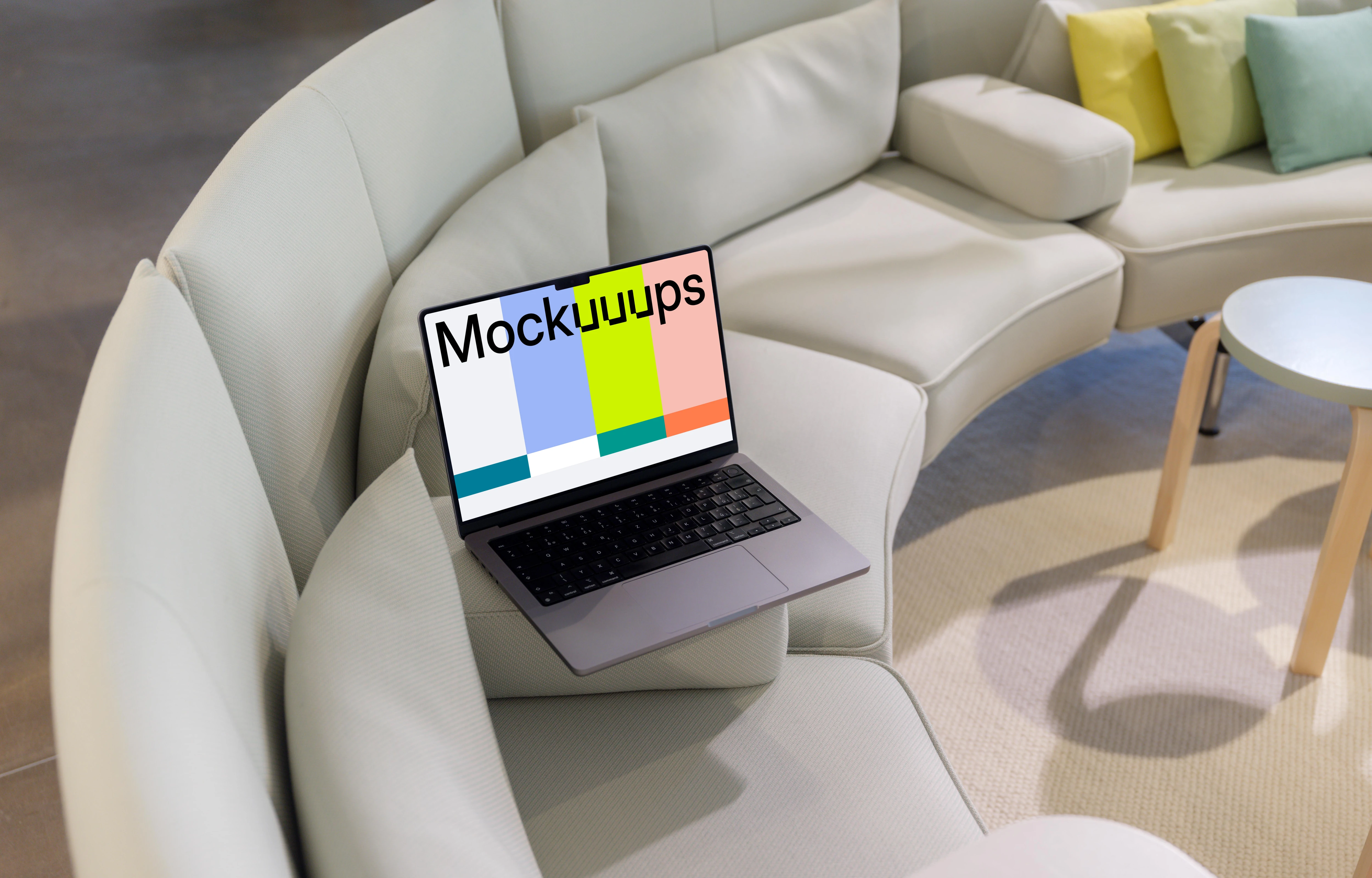 MacBook Pro mockup on modern sofa with colorful cushions