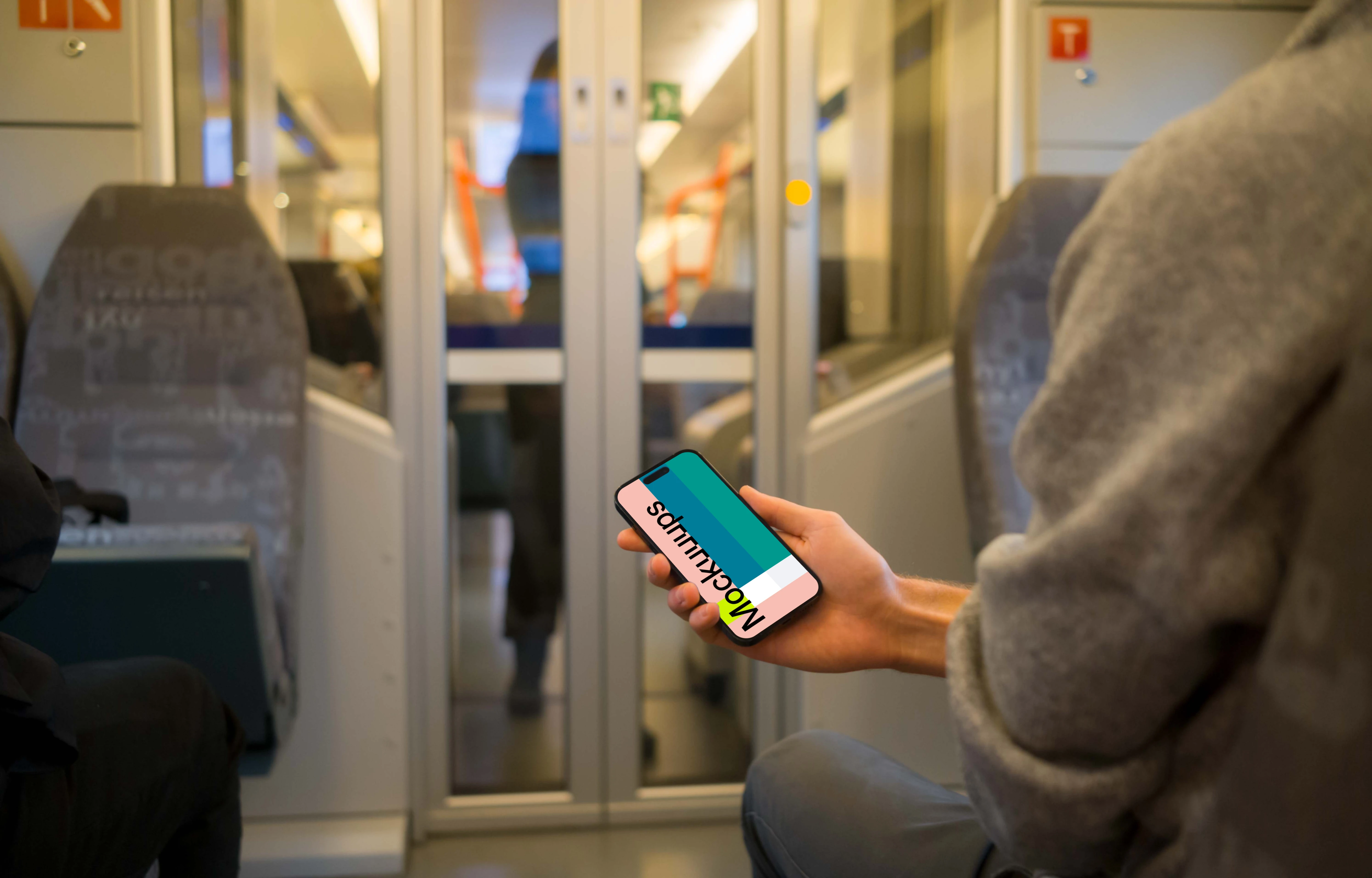 Passenger holding smartphone on the train mockup