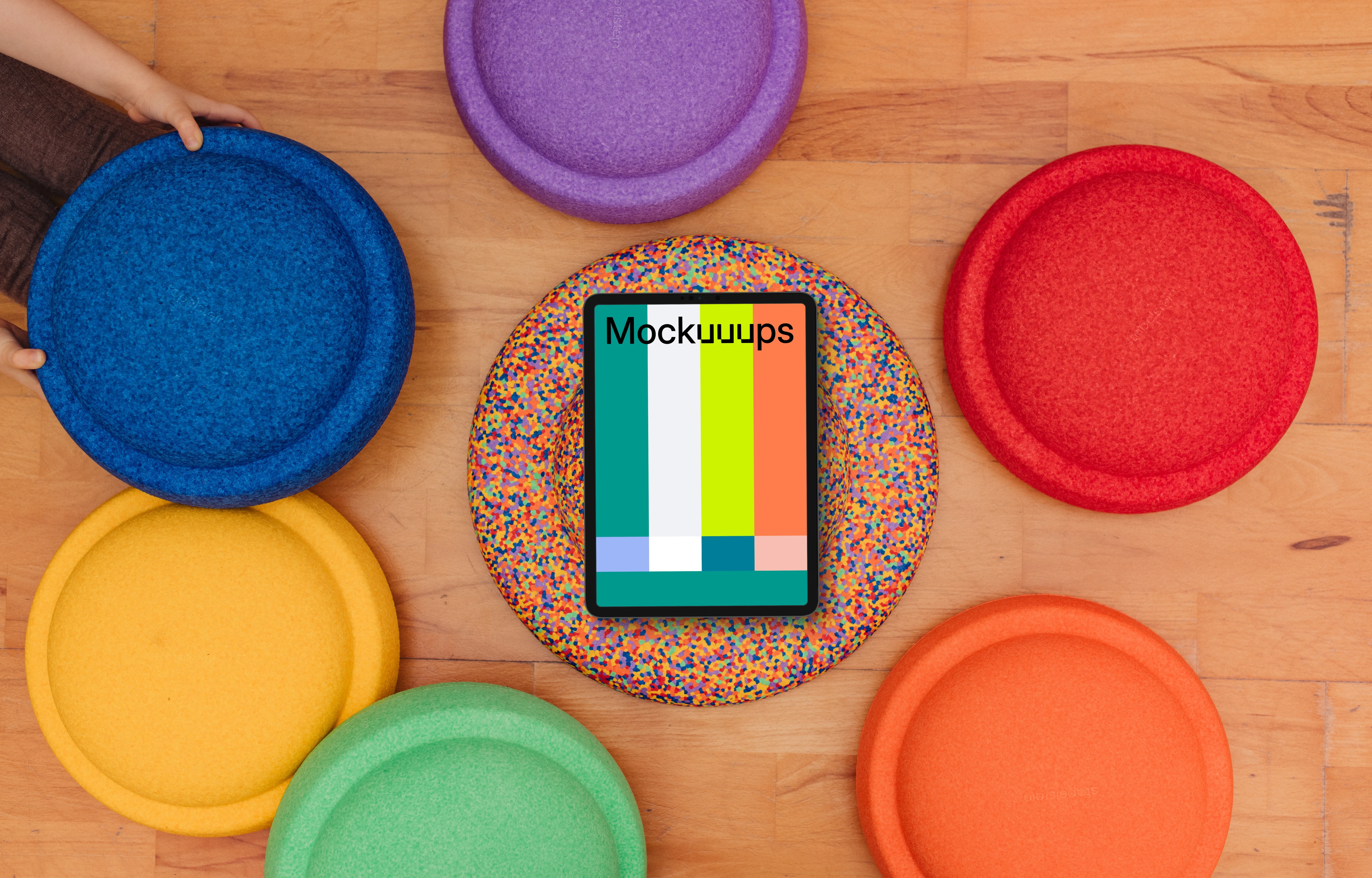 Tablet mockup surrounded by colorful kids seat cushions