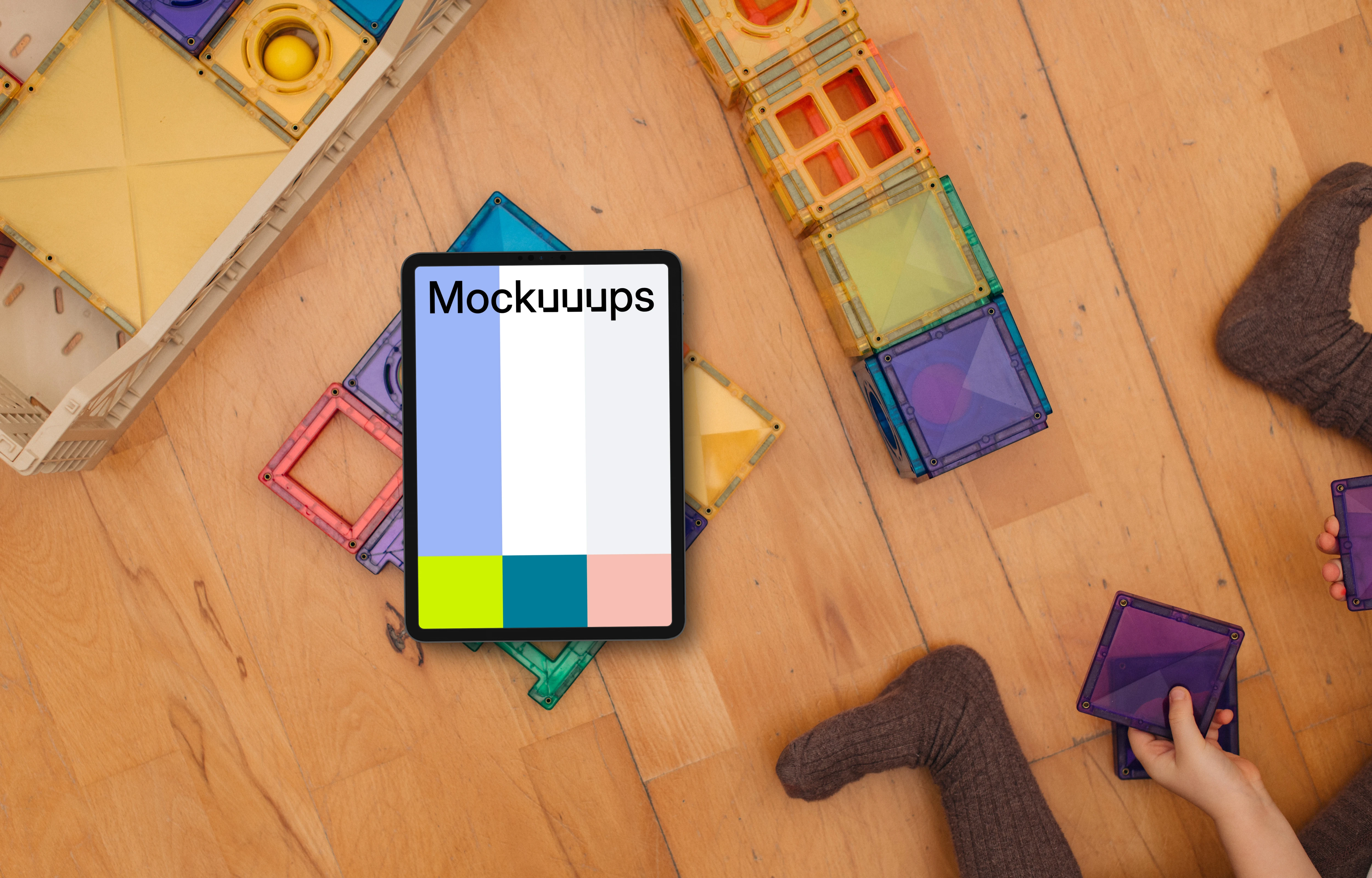 Tablet mockup with colorful building blocks and children's hands