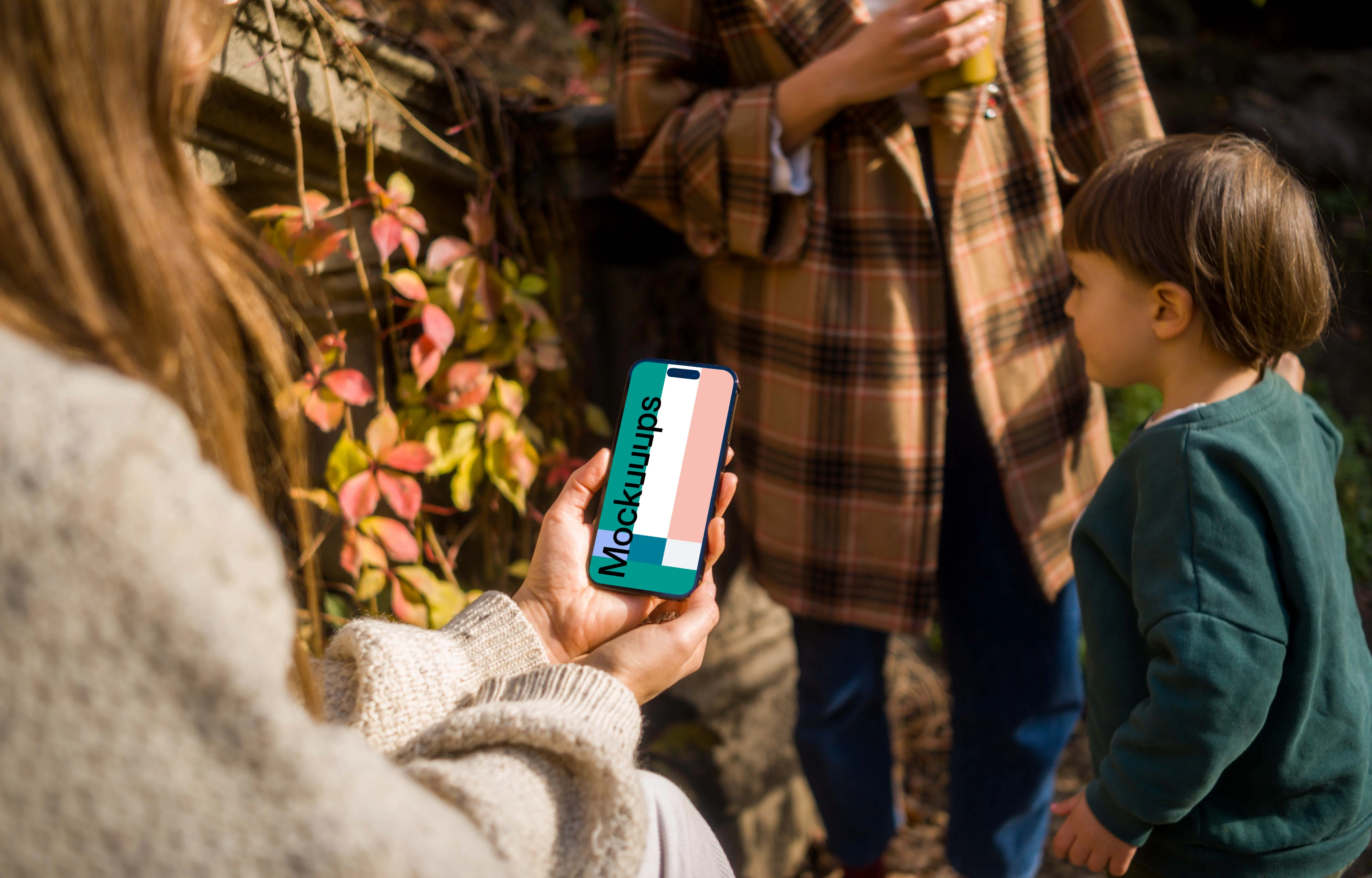 Woman holding an iPhone 14 Pro in garden mockup