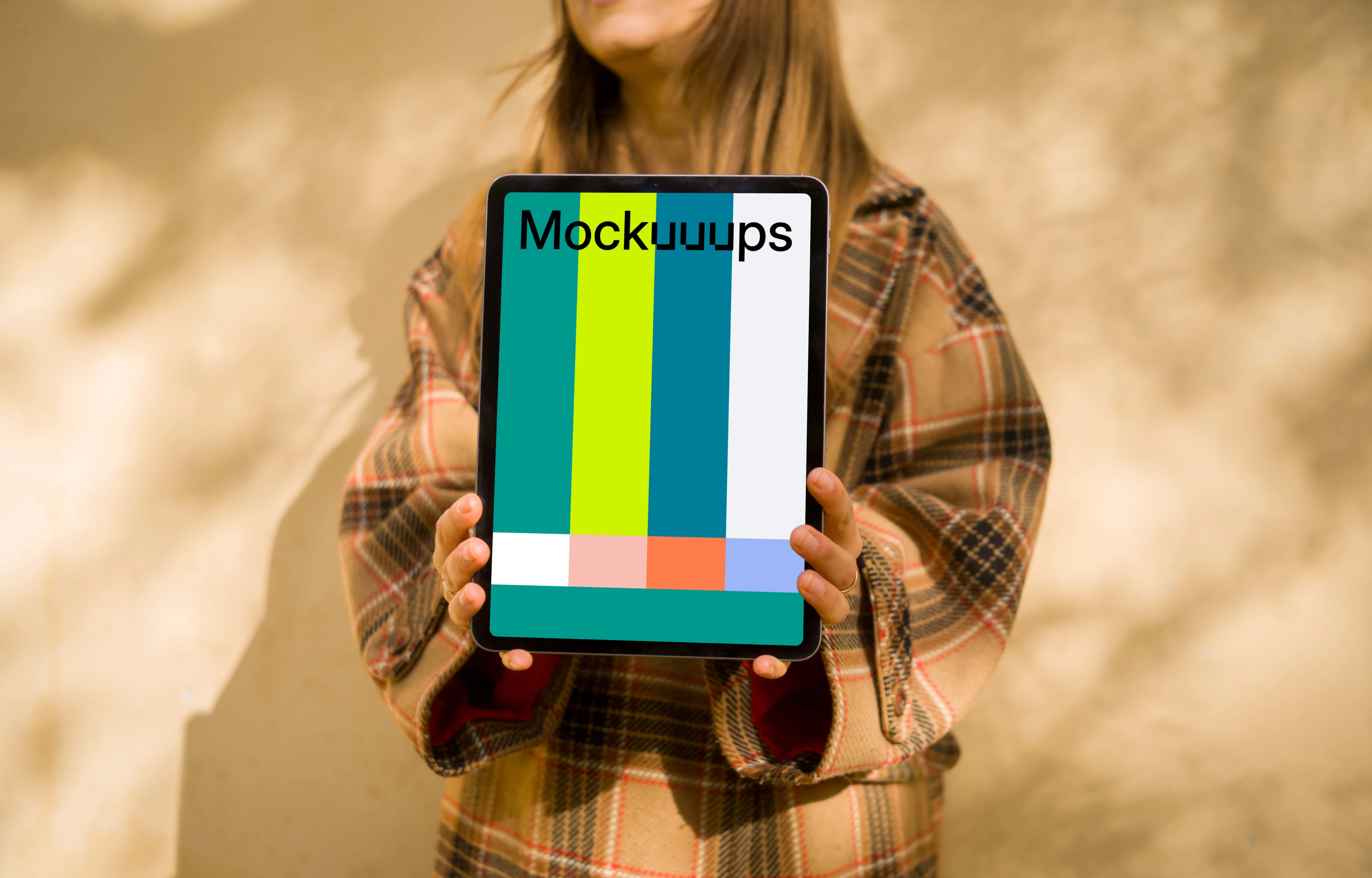 Woman standing in front of wall holding an iPad Air mockup