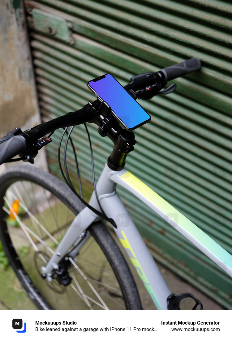 Bike leaned against a garage with iPhone 11 Pro mockup in bike mount