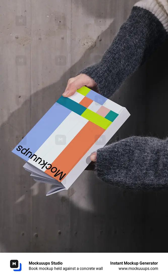 Book mockup held against a concrete wall
