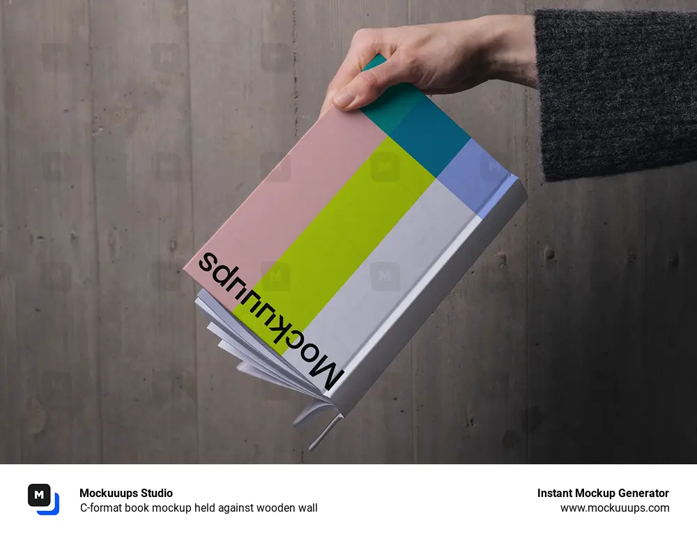 C-format book mockup held against wooden wall