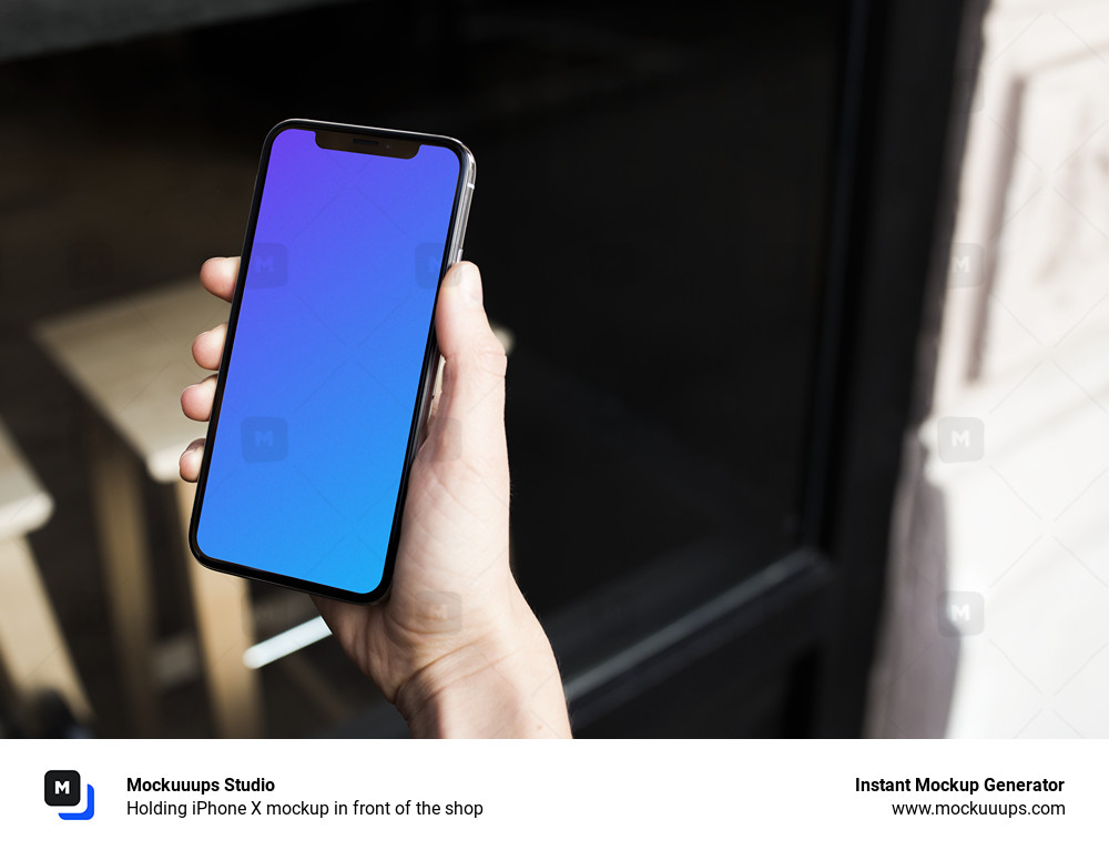 Holding iPhone X mockup in front of the shop