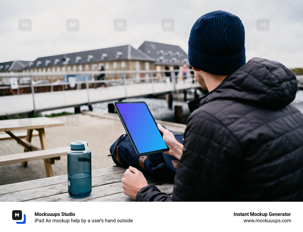  iPad Air mockup help by a user’s hand outside