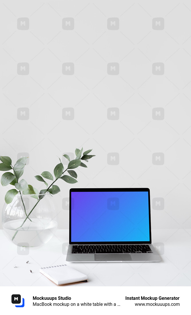 MacBook mockup on a white table with a bowl-shaped flower vase at the side