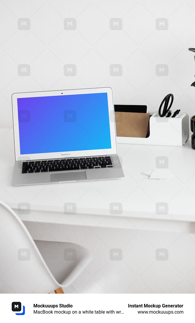MacBook mockup on a white table with writing materials on the side