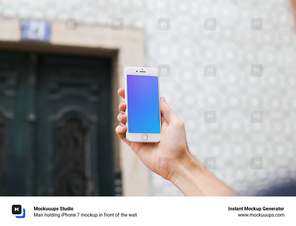 Man holding iPhone 7 mockup in front of the wall