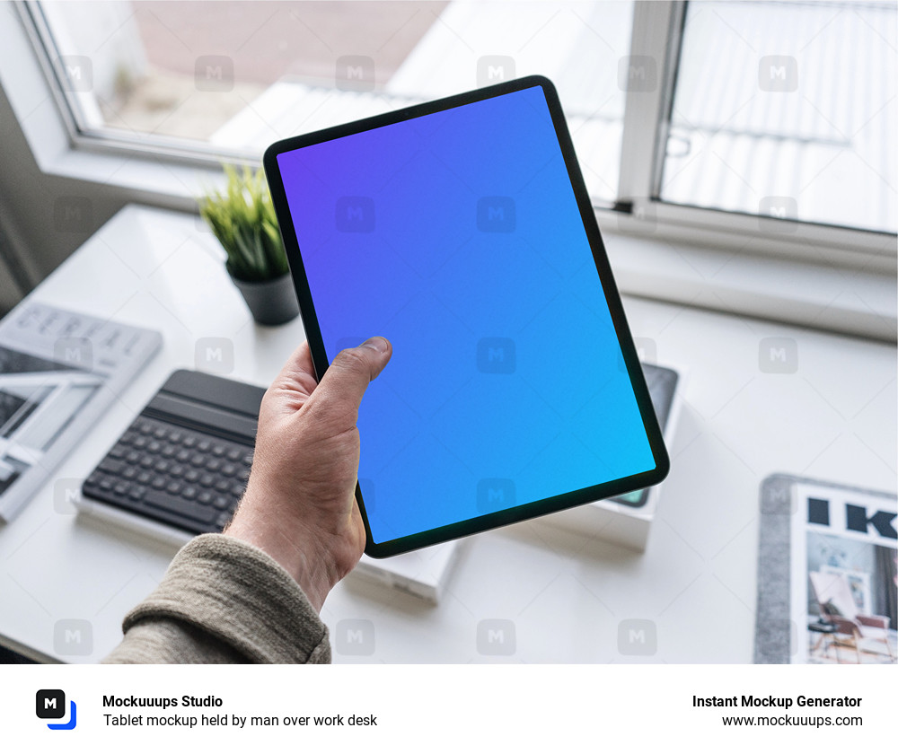 Tablet mockup held by man over work desk 