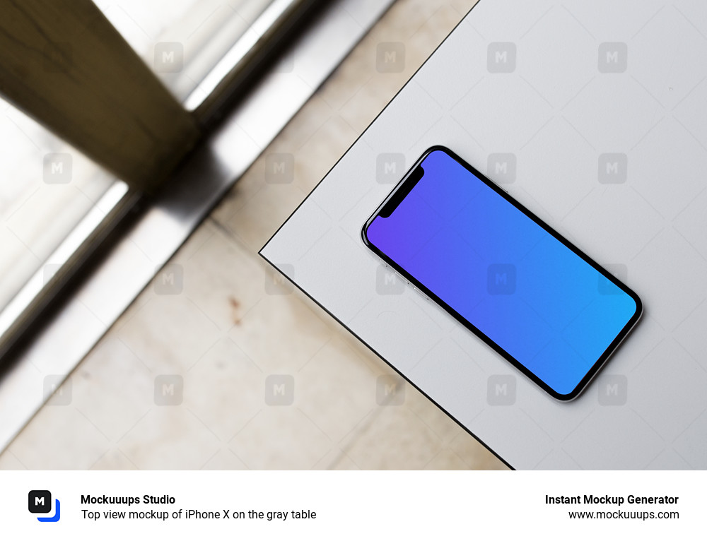 Top view mockup of iPhone X on the gray table
