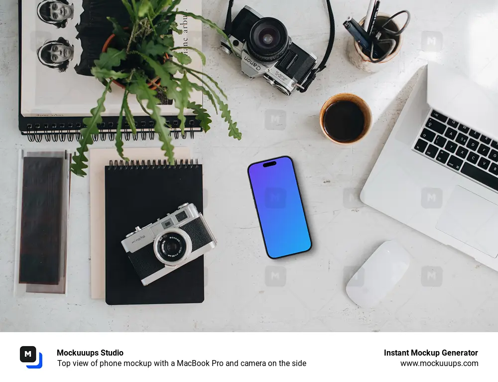 Top view of phone mockup with a MacBook Pro and camera on the side