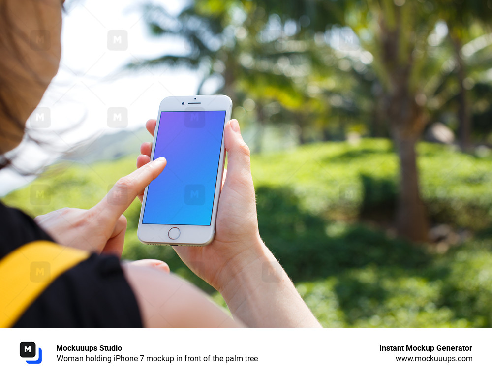 Woman holding iPhone 7 mockup in front of the palm tree