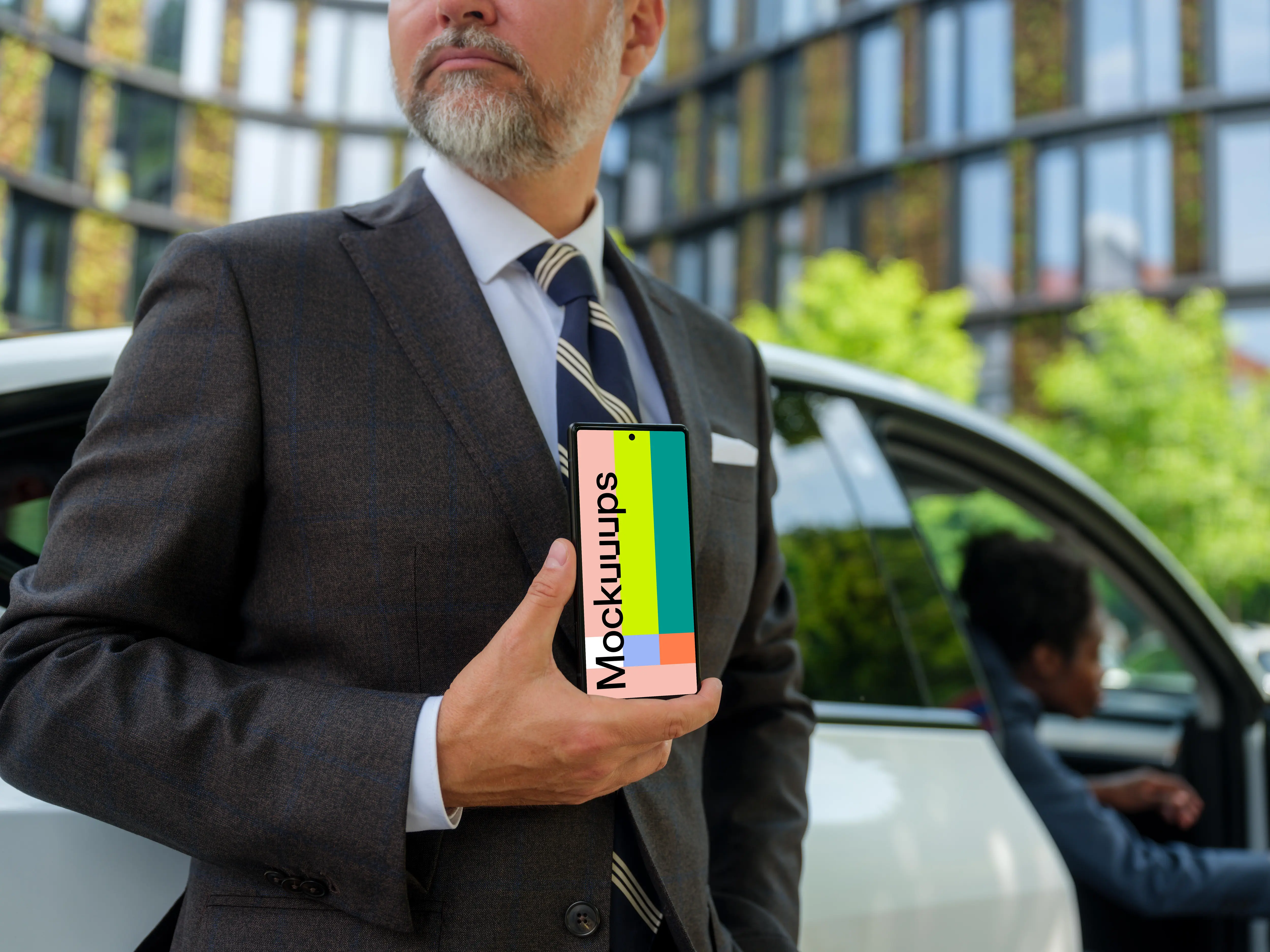Businessman standing next to the Tesla and holding a phone mockup