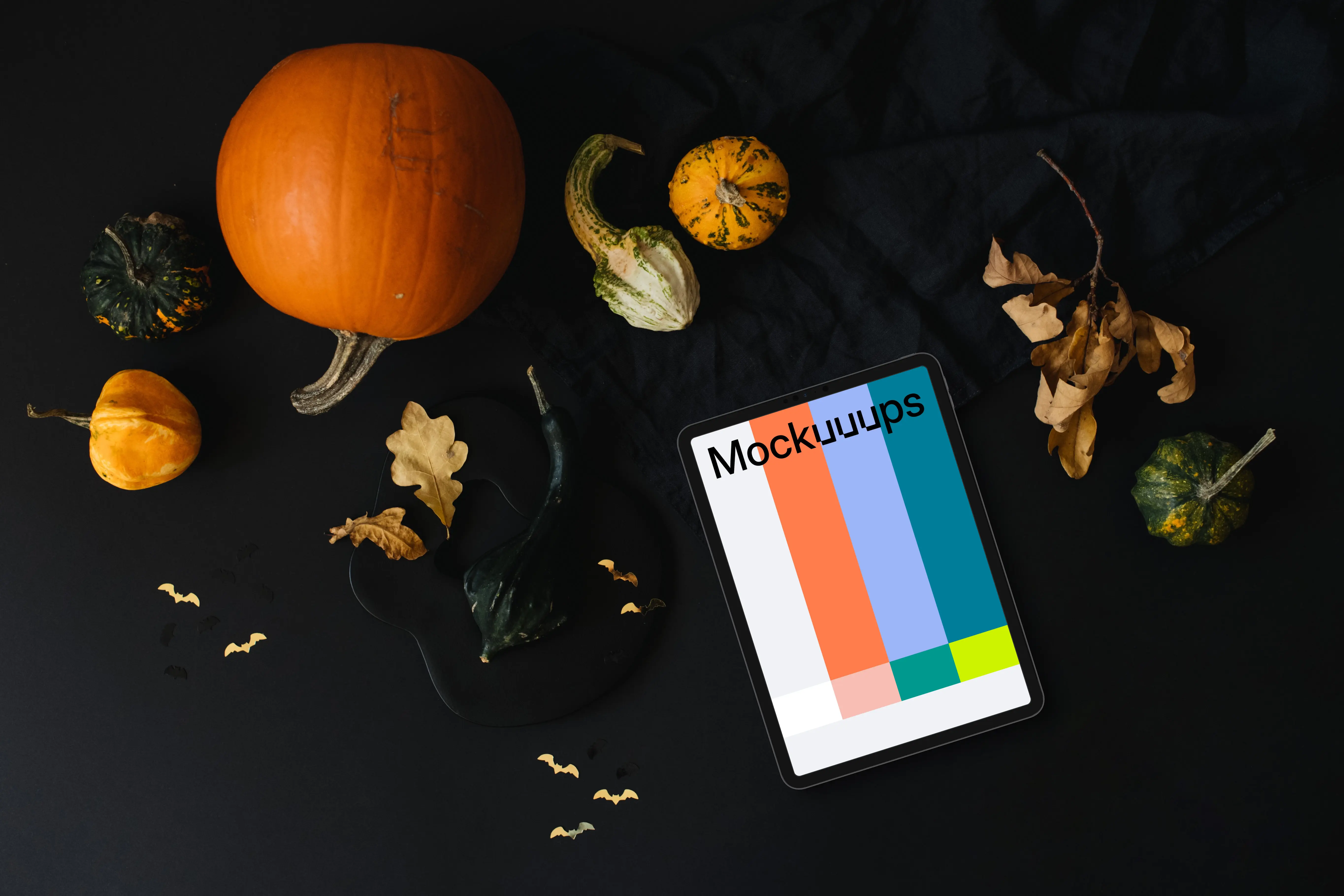 Halloween pumpkin mockup with a tablet and leaves on the side